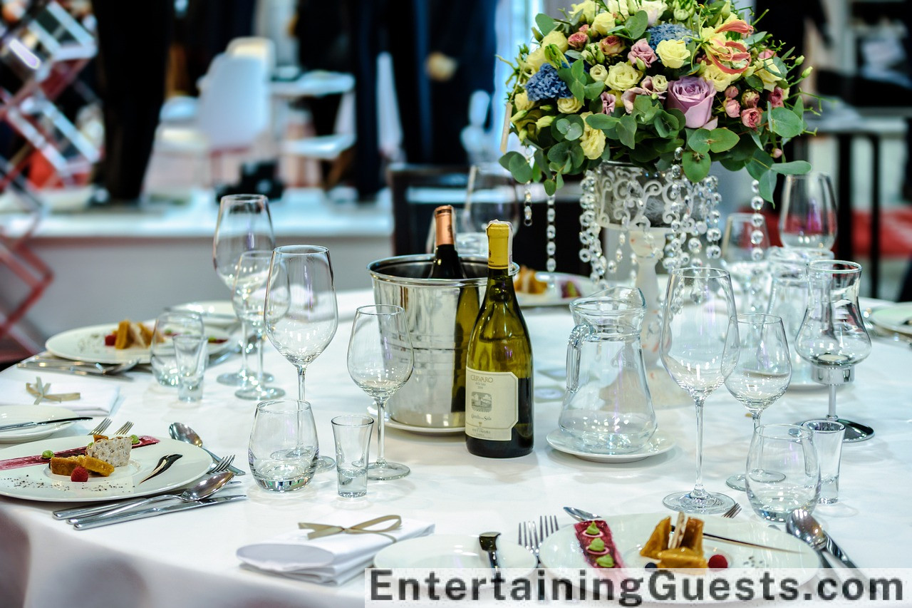 visually rich dinner table scene under soft lighting, featuring a variety of vibrant, gourmet dishes, elegant glassware, and a centerpiece of fresh flowers, exuding an inviting and celebratory atmosphere