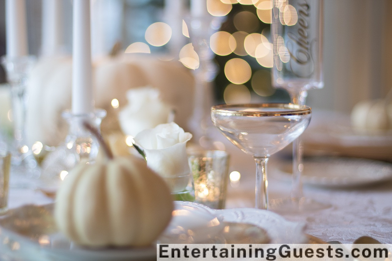 An image featuring a rustic table setting with a golden turkey centerpiece, surrounded by colorful autumn leaves, pumpkins, and candles, with guests laughing and toasting with glasses of cider