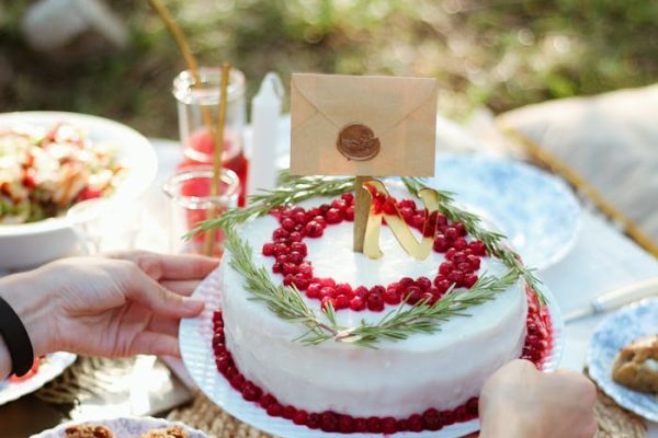 White and Red Cake With Lighted Candles on Table